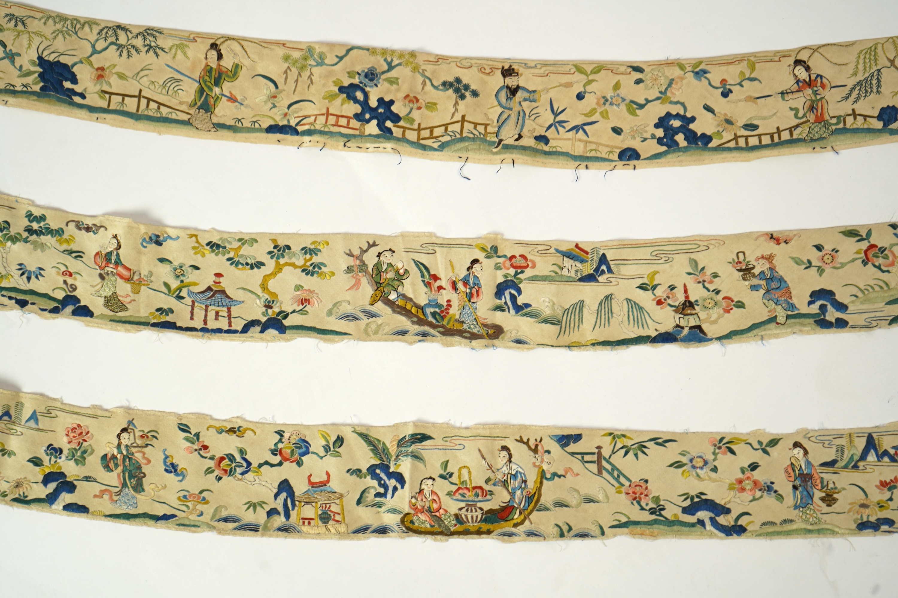 A Chinese embroidered silk panel of uncut robe borders, eleven similar sleeve panels and two other items, late Qing dynasty